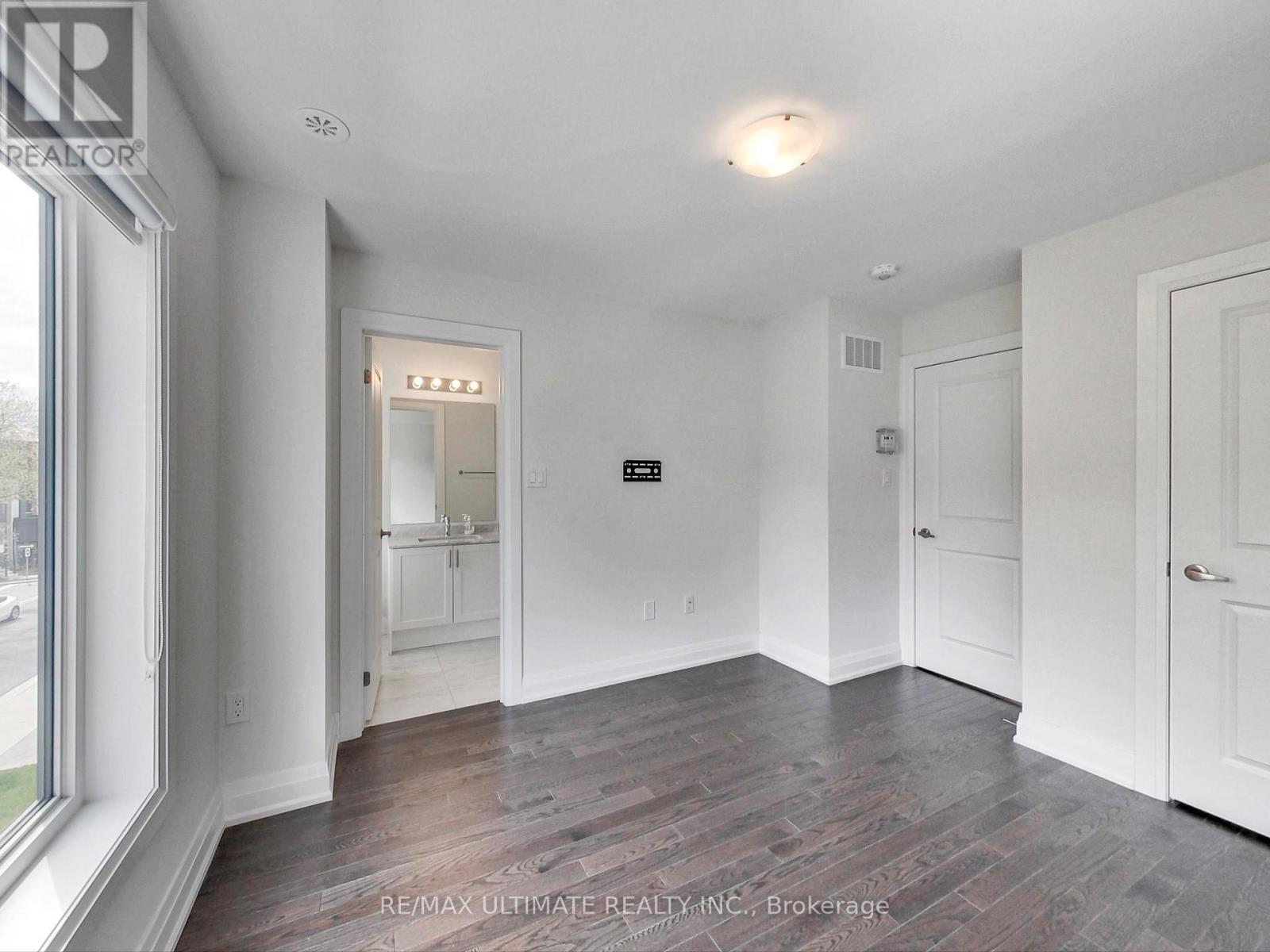 A spacious room with a doorway leading to another room.
