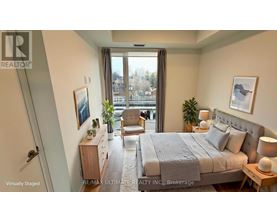 A bedroom with a large bed, a chair, and a window overlooking a cityscape.