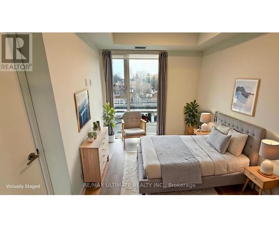 A bedroom with a large bed, a chair, and a window overlooking a cityscape.