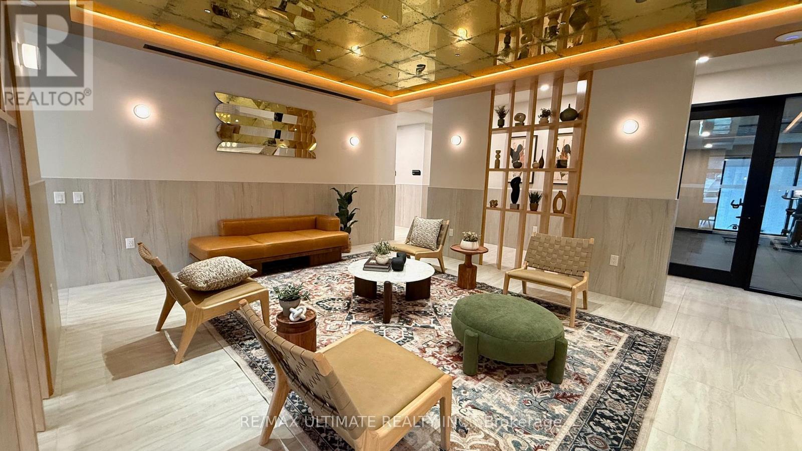 A living room with a sofa, chairs, and a rug.