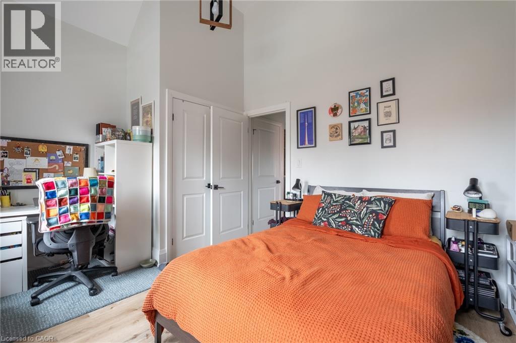 A bedroom with a bed, a desk with a chair, and a bulletin board on the wall.