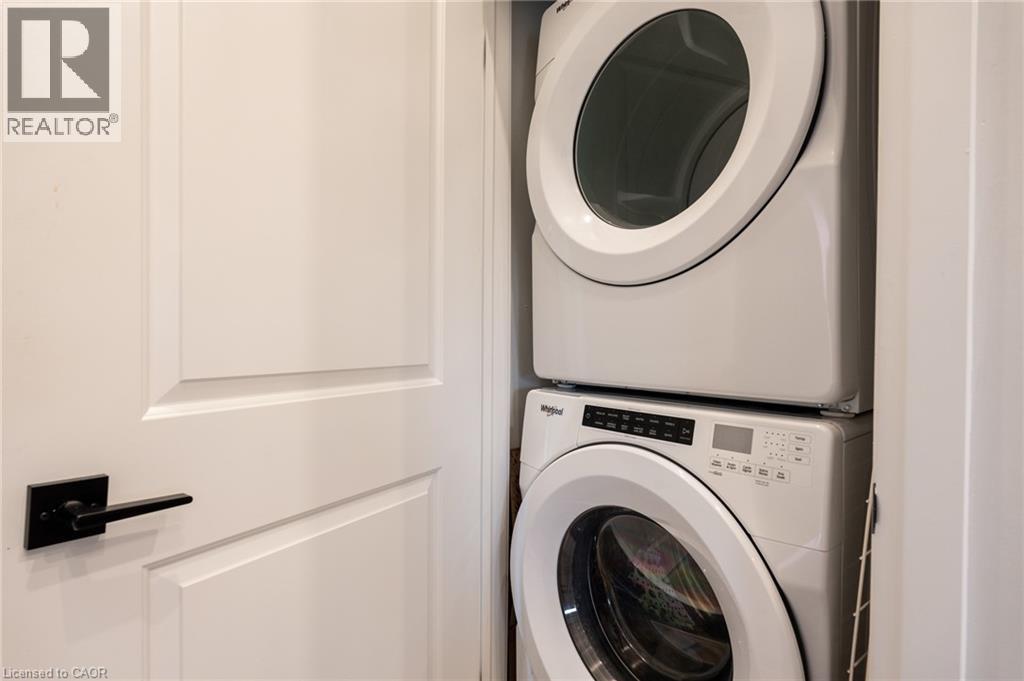 A washing machine is stacked on top of another one in a small space.