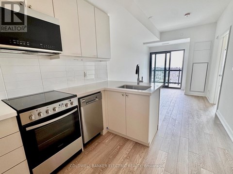 A kitchen with a black stove top oven and white cabinets.