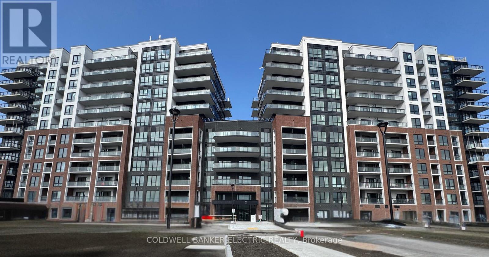 Two identical buildings with balconies and windows are situated next to each other.