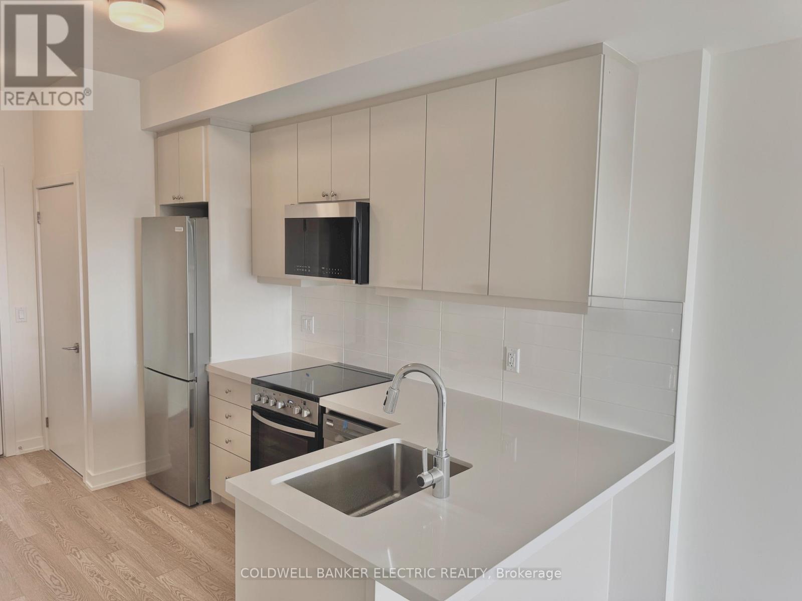 A kitchen with white cabinets and a sink.