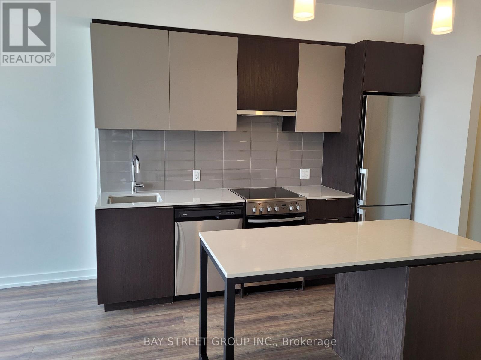 A kitchen with a table and a refrigerator.