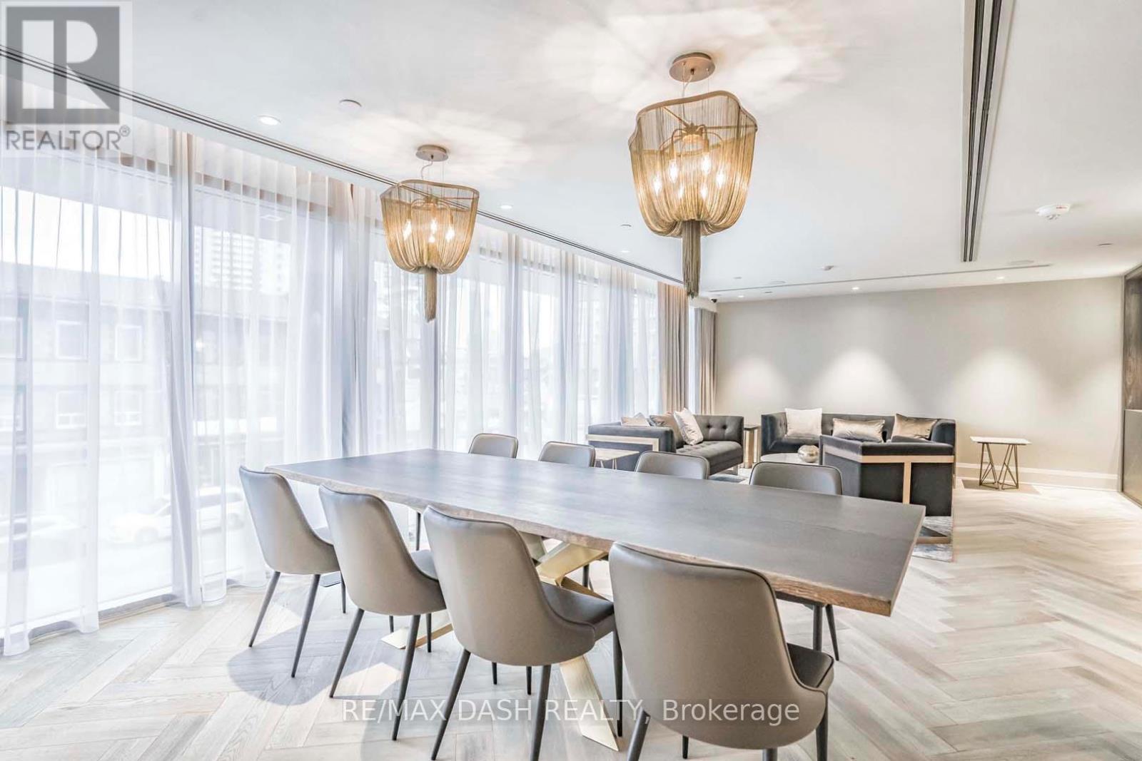 A dining room with a large table and chairs.