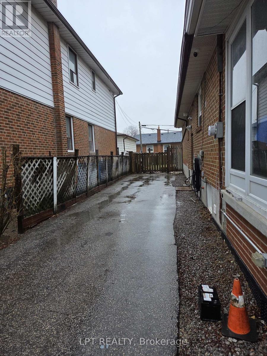 A wet residential street with a traffic cone and a black box on the ground.