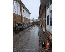 A wet residential street with a traffic cone and a black box on the ground.
