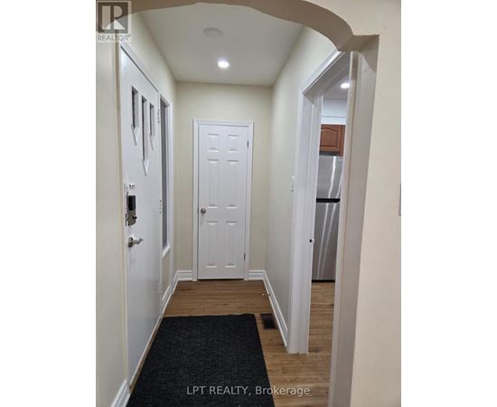 A hallway with a black doormat and white doors.