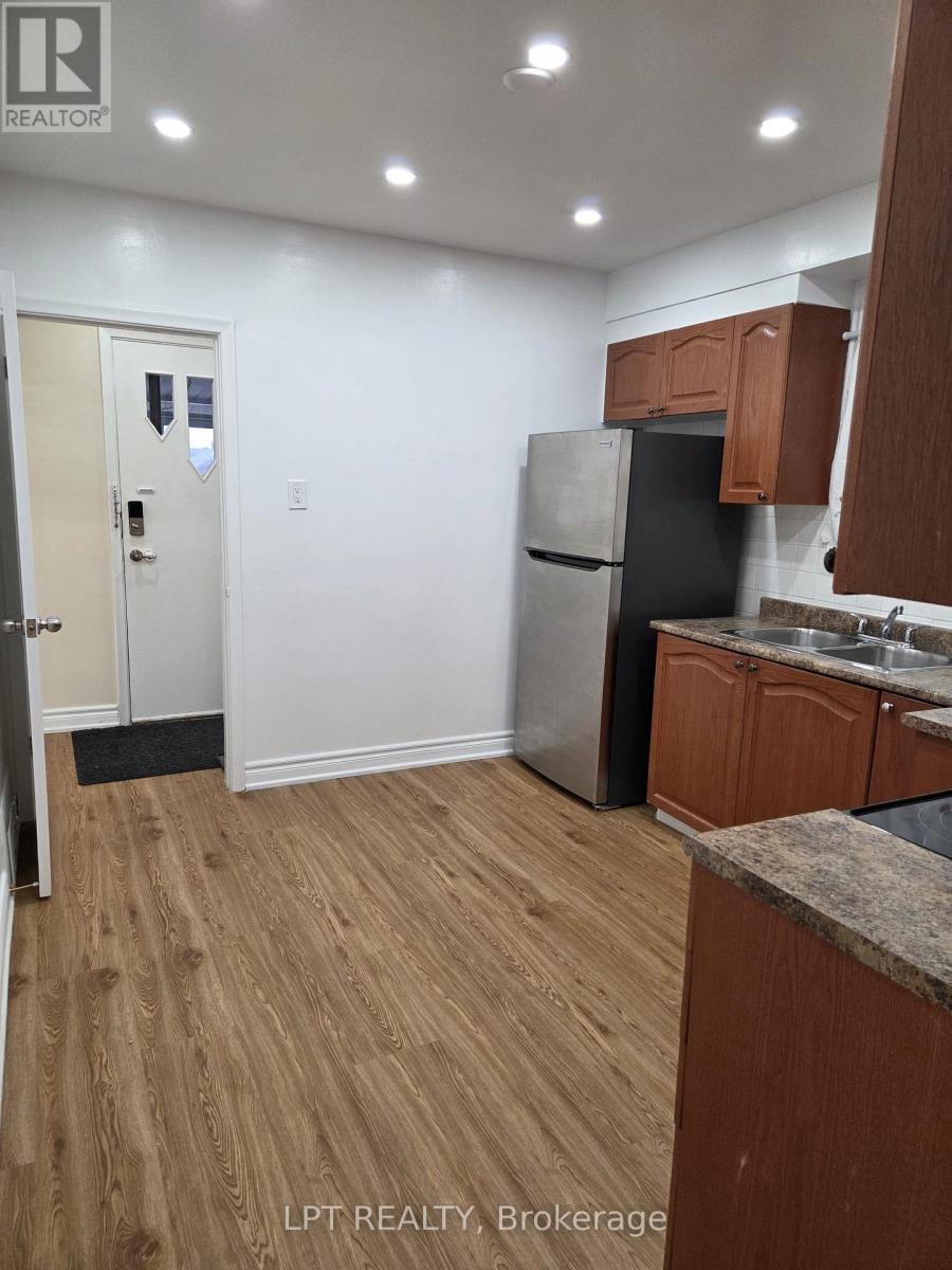 A kitchen with wooden cabinets and a refrigerator.
