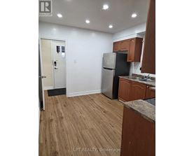 A kitchen with wooden cabinets and a refrigerator.