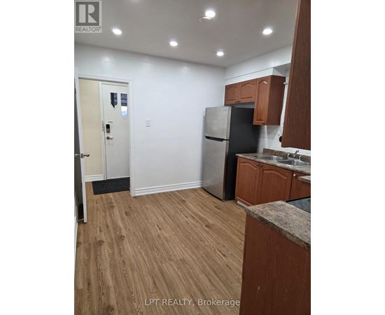 A kitchen with wooden cabinets and a refrigerator.