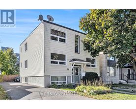 A house with a grey facade and a white door is for sale.