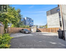 A car is parked in a driveway with a building in the background.