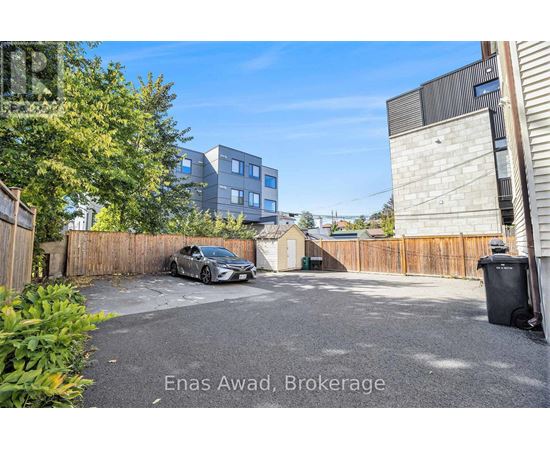 A car is parked in a driveway with a building in the background.