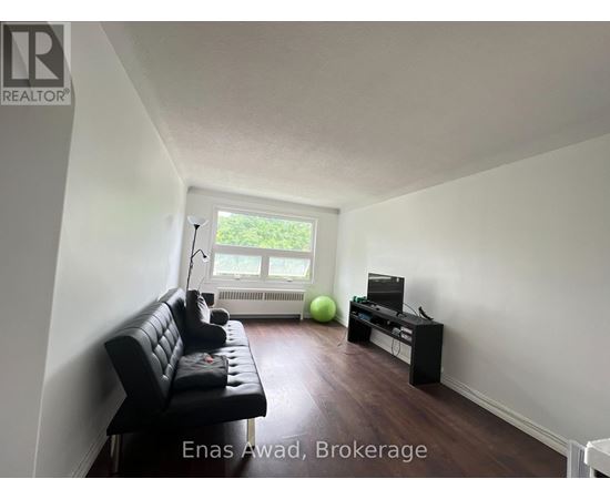 A living room with a black leather sofa and a green exercise ball.