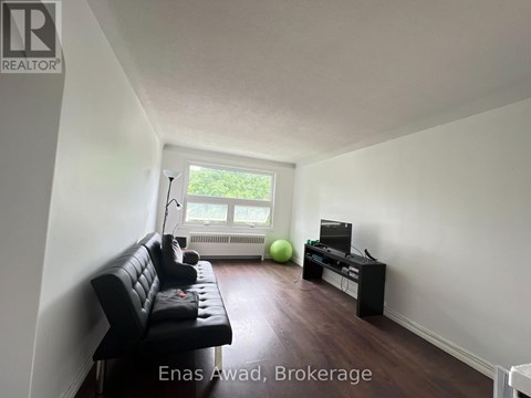 A living room with a black leather sofa and a green exercise ball.