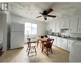 A kitchen with white cabinets and a table with chairs.
