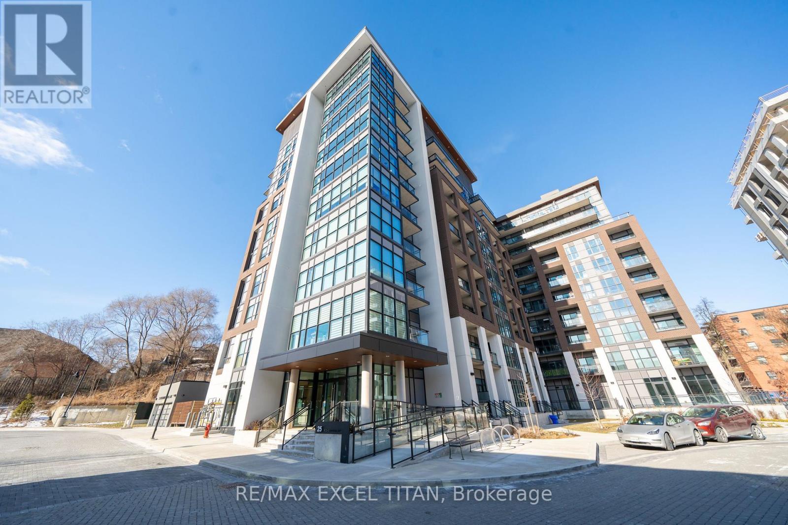 A modern building with glass windows and a sign that reads "RE/MAX EXCEL TITAN, Brokerage".