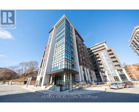 A modern building with glass windows and a sign that reads "RE/MAX EXCEL TITAN, Brokerage".