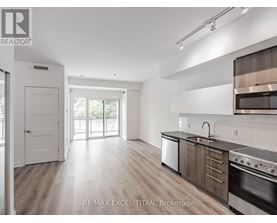 A modern kitchen with wooden floors and stainless steel appliances.