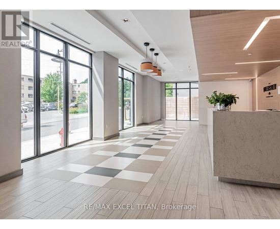 A spacious office lobby with a reception desk and large windows.