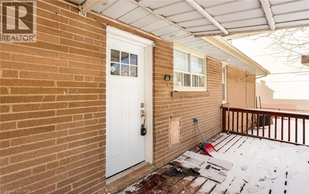 A white door is on the left side of a brick wall.