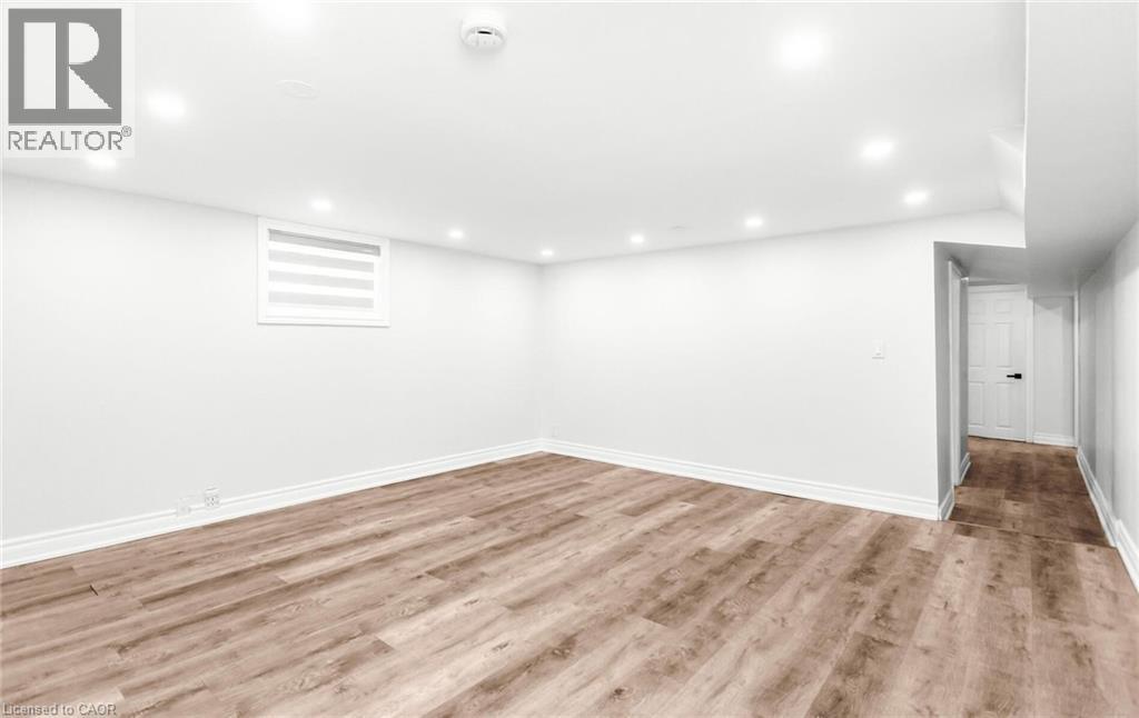 A spacious room with wooden flooring and white walls.
