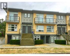 A two-story apartment building with a balcony on the second floor.