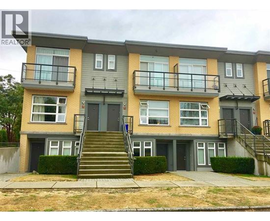 A two-story apartment building with a balcony on the second floor.