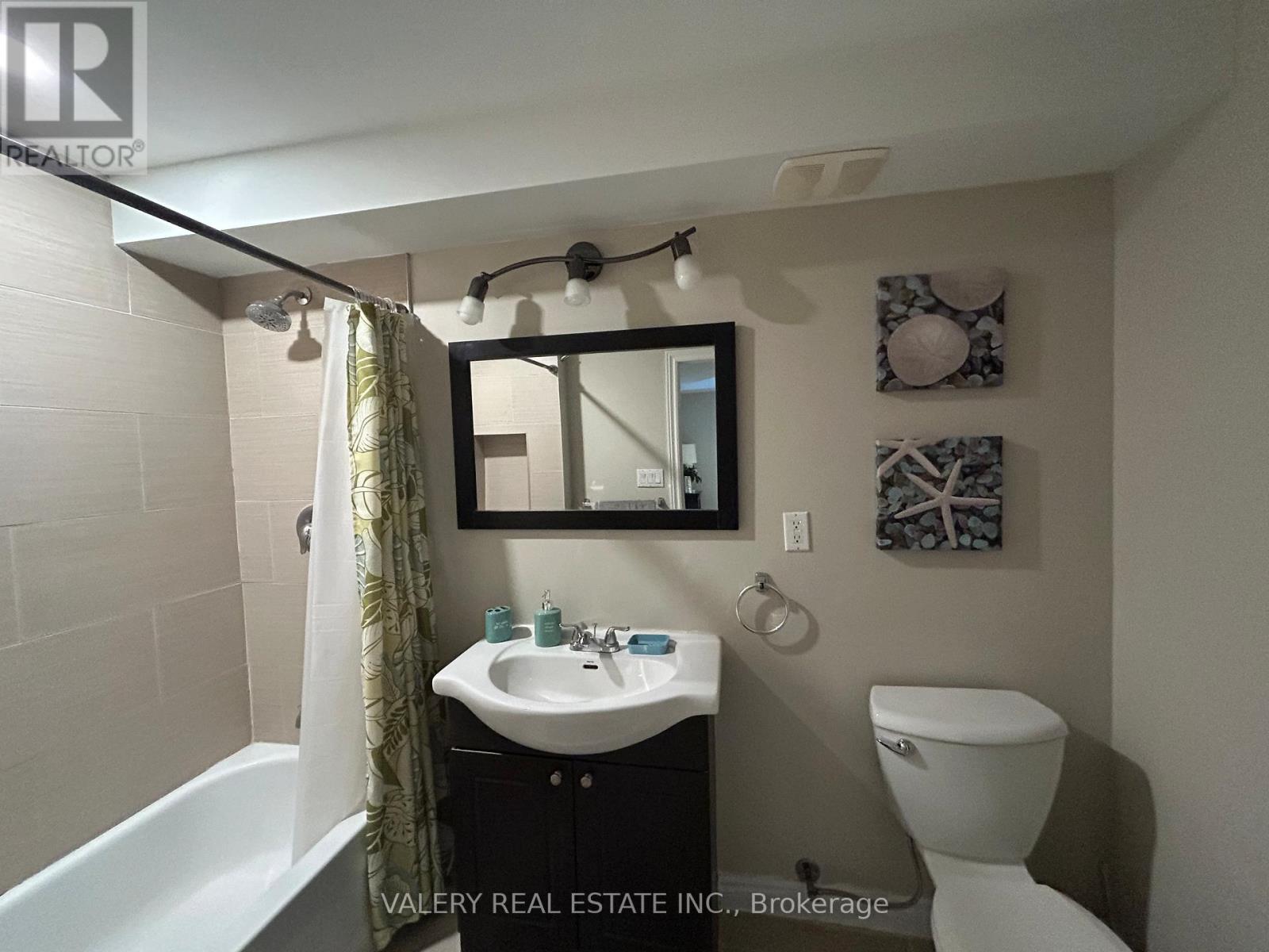 A bathroom with a white sink and toilet.