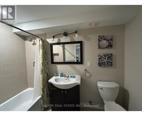 A bathroom with a white sink and toilet.