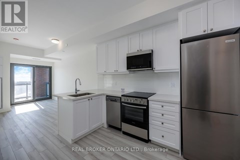 A kitchen with white cabinets and a stainless steel refrigerator.