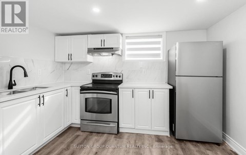 A kitchen with white cabinets and appliances.