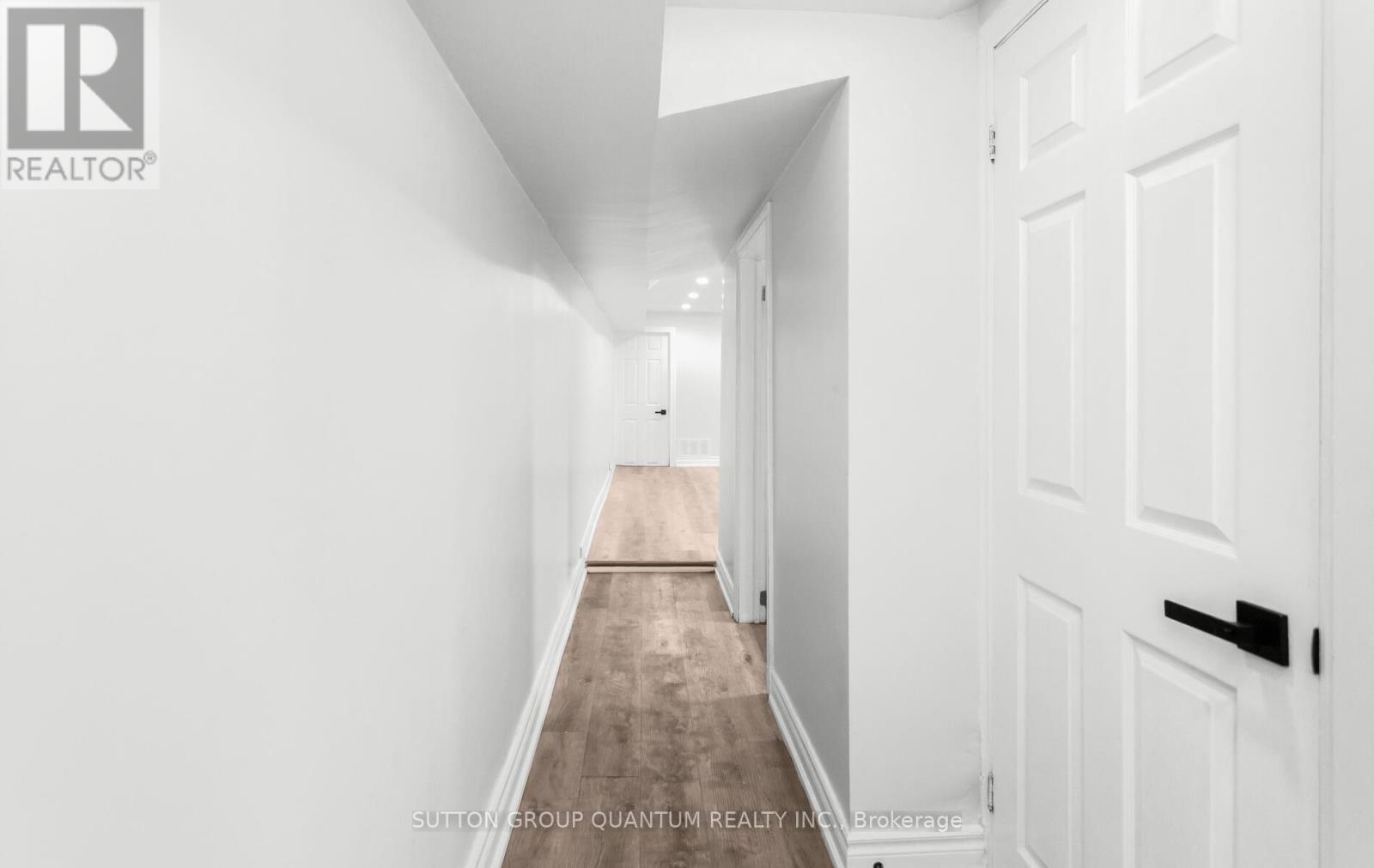 A hallway with a carpeted floor and white walls.