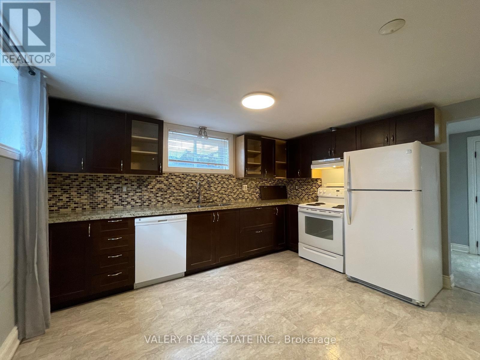 A kitchen with brown cabinets and a white refrigerator.