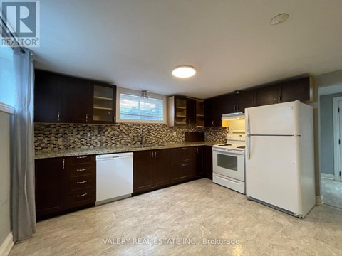 A kitchen with brown cabinets and a white refrigerator.