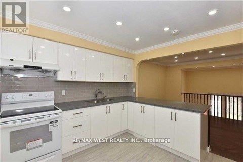 A kitchen with white cabinets and a stove top oven.
