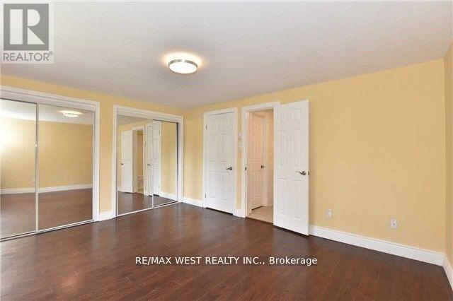A spacious room with wooden floors and white doors.