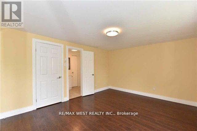 A room with a white door and a wooden floor.