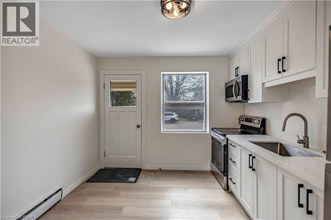A kitchen with white cabinets and a black stove top oven.