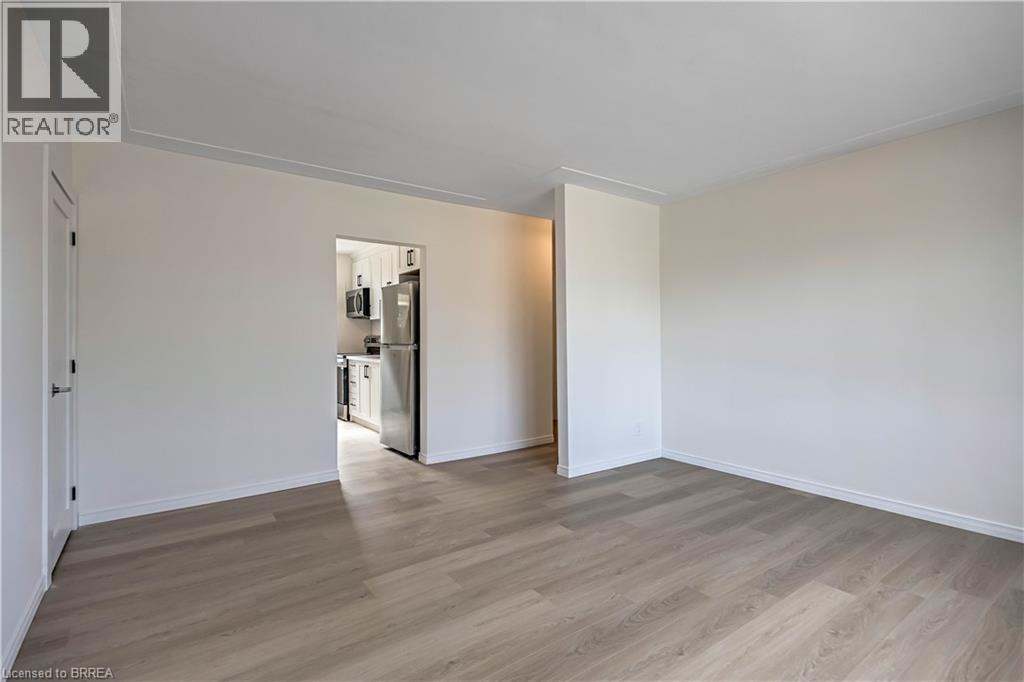 A spacious room with a kitchen area in the background.