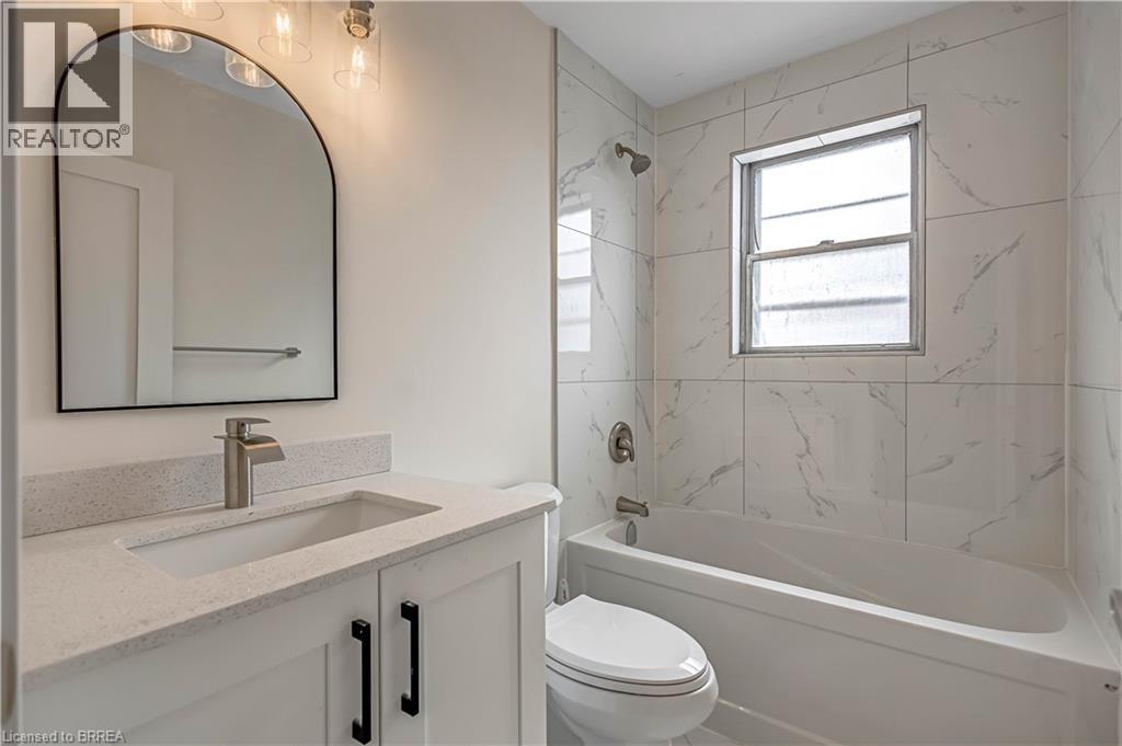 A bathroom with a marble wall and a white toilet.