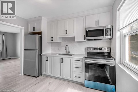 A kitchen with white cabinets and a stainless steel oven.