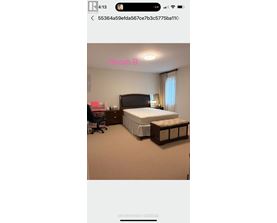 A bedroom with a bed, nightstand, and chair.