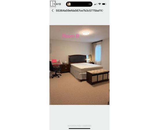 A bedroom with a bed, nightstand, and chair.