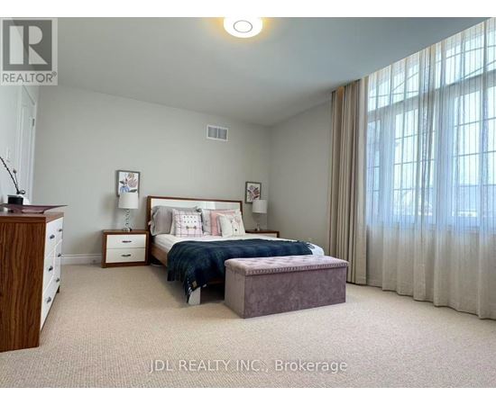 A bedroom with a bed, nightstand, and window with curtains.