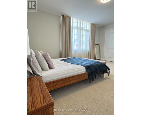 A bedroom with a bed, pillows, and a blanket.