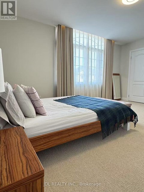 A bedroom with a bed, pillows, and a blanket.
